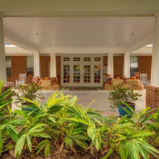 A cozy outdoor porch with comfortable seating and lush greenery.