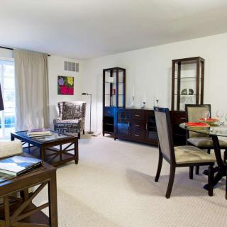A cozy living and dining area with modern furniture and neutral colors.