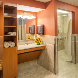 A well-designed bathroom featuring a sink, mirror, and an inviting arrangement of towels and flowers.