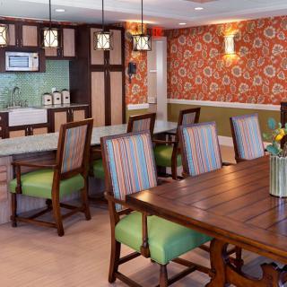 A stylish dining area featuring modern furniture and floral wallpaper.