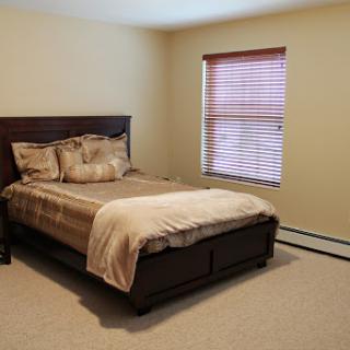 A cozy and neatly arranged bedroom featuring a comfortable bed and soft lighting.