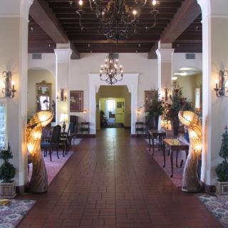 A traditional lobby with chandeliers, seating areas, and decorative lamps.