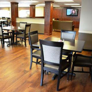 A clean and modern dining area with neatly arranged tables and chairs.