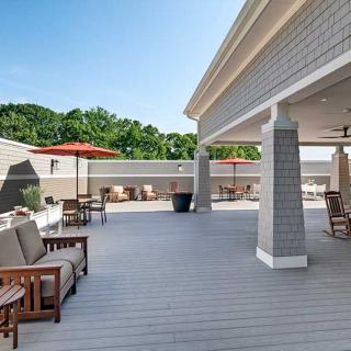 A spacious outdoor patio with comfortable seating, umbrellas, and a clear blue sky.