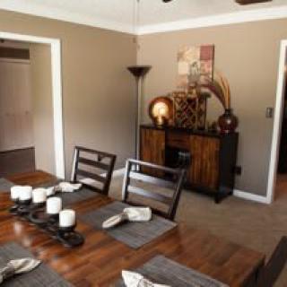 A cozy dining room with wooden furniture and a candle-lit table setting.