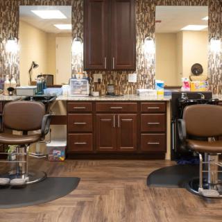 A cozy and well-organized barbershop with two styling chairs facing large mirrors.