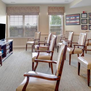 A well-arranged seating area with chairs facing a television, suitable for meetings or presentations.