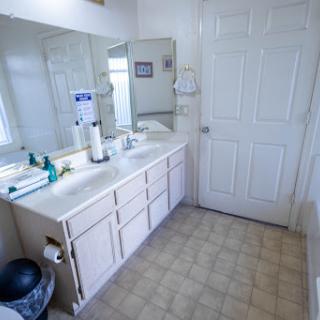 A spacious and clean bathroom featuring a dual-sink vanity and large mirror.
