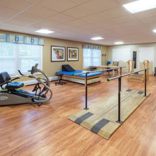 A well-equipped rehabilitation and exercise room featuring fitness equipment and therapy areas.