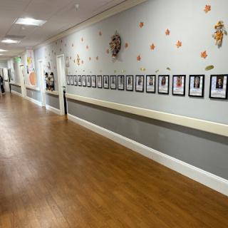 A hallway featuring a series of framed photographs along the wall, adorned with colorful decorations.