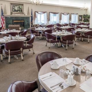 A formal dining room with multiple set tables ready for service.