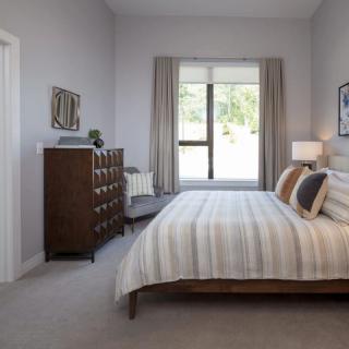 A cozy bedroom with a neatly made bed and elegant furnishings.