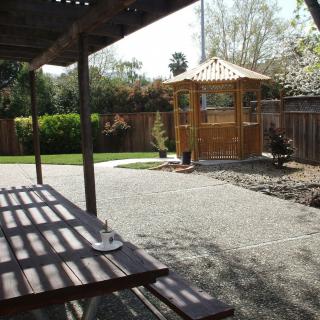 A serene backyard with a gazebo, picnic table, and well-maintained garden.