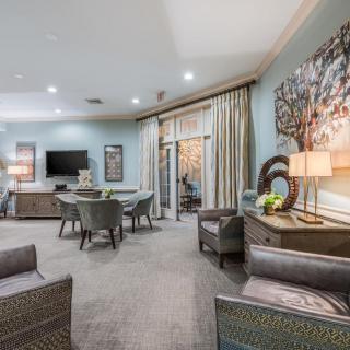 A modern living room featuring stylish furniture, a dining area, and a television.