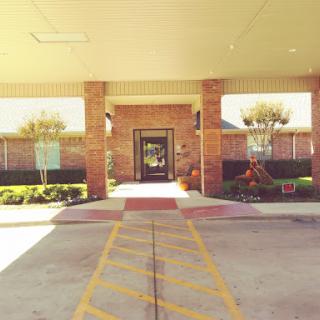 A welcoming entrance to a building with decorative landscaping and clear pathways.