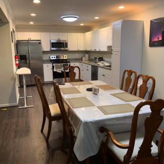 A modern kitchen and dining area with a wooden table and chairs.