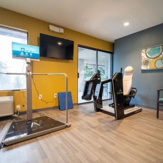 A modern gym facility with exercise equipment and a treadmill.
