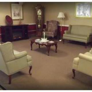 A cozy living room featuring a set of chairs and a sofa around a central coffee table.