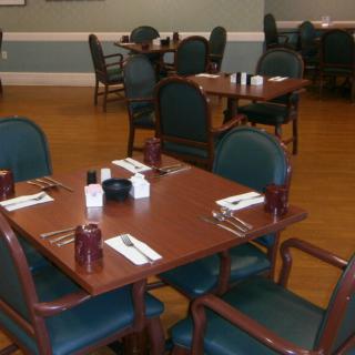 An empty dining area with wooden tables set for guests.