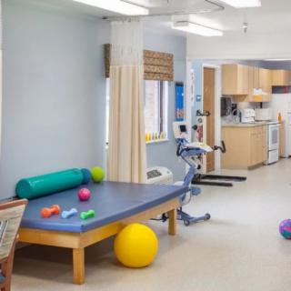 A physical therapy room equipped with exercise balls, mats, and other rehabilitation tools.