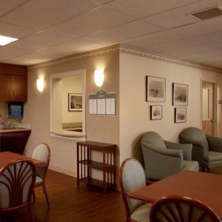 A cozy lounge area with comfortable seating and warm lighting, featuring artwork on the walls.