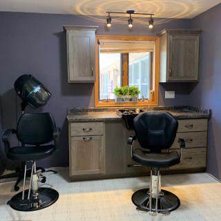 A modern hair salon setup featuring sleek styling chairs and a hair dryer station.