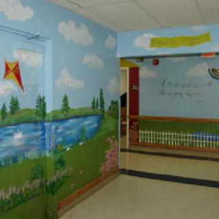 A colorful mural of a lake and kites decorates the walls of a children's area.