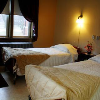 A cozy hotel room featuring two twin beds, warm lighting, and soft decor.