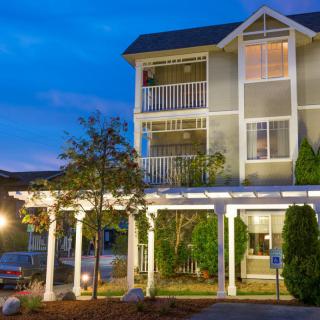 A well-lit apartment building with multiple balconies during the evening.