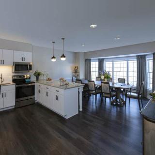 A modern open-concept kitchen and dining area with sleek design elements and hardwood flooring.