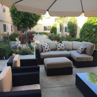 A cozy patio with outdoor seating, surrounded by a neatly landscaped garden.