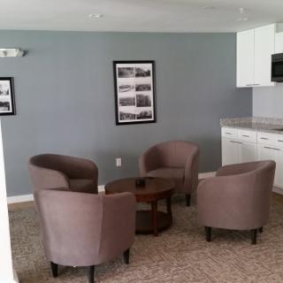 A cozy seating area with four chairs and a round coffee table in a modern living space.