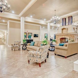 A spacious and elegant living room with luxurious furnishings and a grand fireplace.
