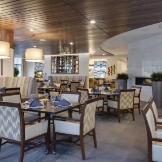A modern restaurant interior with neatly arranged tables and stylish lighting.