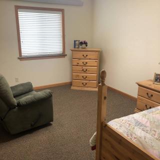 A simple bedroom with wooden furniture and a single bed.