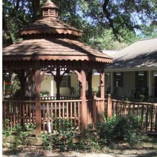 A charming wooden gazebo surrounded by greenery provides a peaceful outdoor retreat.