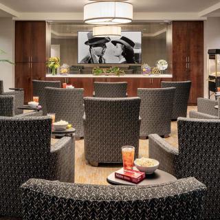 A cozy lounge area with comfortable seating, a large movie screen, and snacks ready for enjoyment.