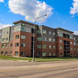 A modern residential apartment building under a bright sky.