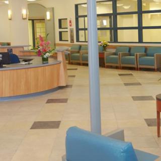 A modern hospital waiting room with seating and a reception desk.
