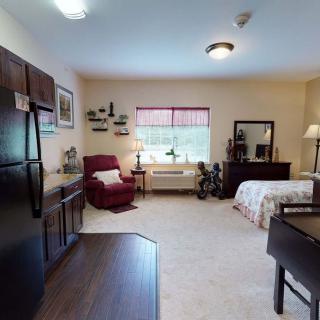 A cozy apartment interior featuring a combined living and bedroom space with a kitchen area.