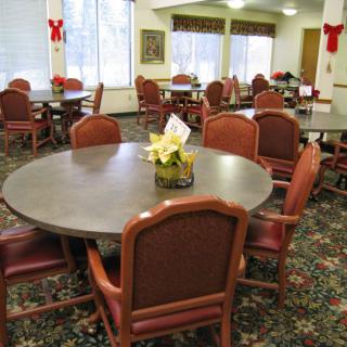 A dining area with round tables and chairs, decorated for the holidays.