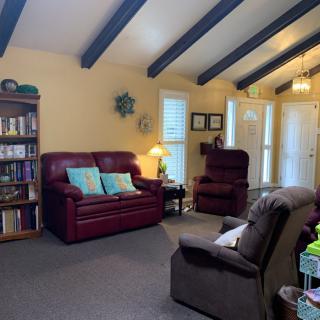 Cozy living room with comfortable seating and a well-stocked bookshelf.