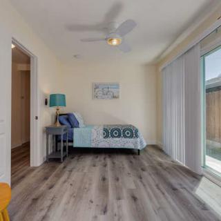 A minimalist bedroom with a single bed, modern decor, and ample natural light from the sliding door.