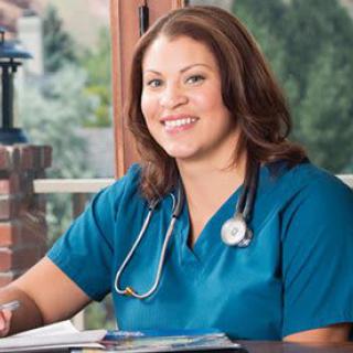 A healthcare professional in a medical uniform smiling while seated indoors.