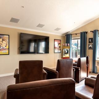 A cozy home theater room with comfortable seating and a large screen, complemented by movie posters on the walls.