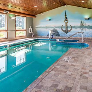 An indoor swimming pool with a nautical-themed mural featuring an anchor.