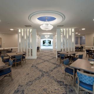 A modern dining area featuring elegant lighting and spacious seating arrangements.