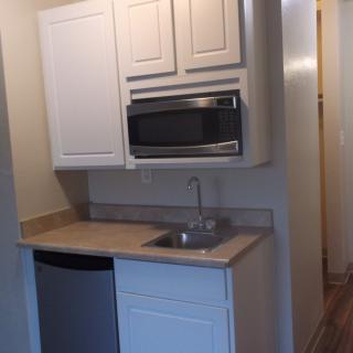 A compact kitchenette featuring a microwave and small sink area.