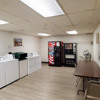 A clean laundry room with washing machines and vending machines.