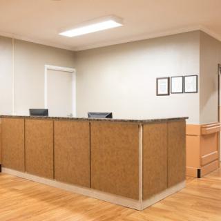 A modern office reception area with a wooden front desk and a welcoming atmosphere.